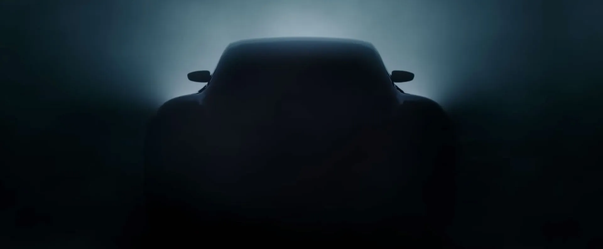 The Taycan’s silhouette emerging from dark haze